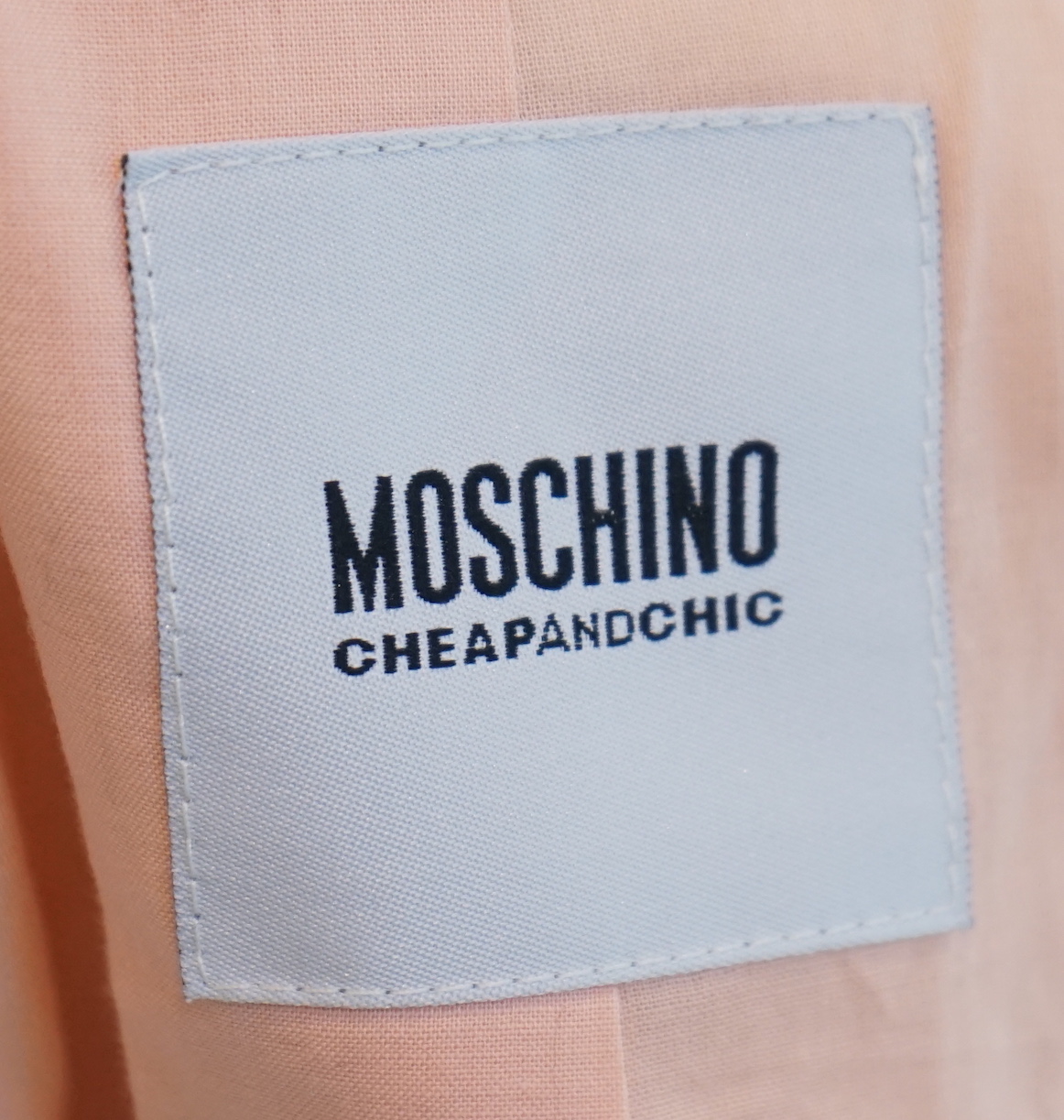 A Moschino lady's long blue and red jacket, a cream cotton embellished blazer and a cotton pair of floral trousers, blue and red jacket size 14, cream blazer size 12, trousers size: 10